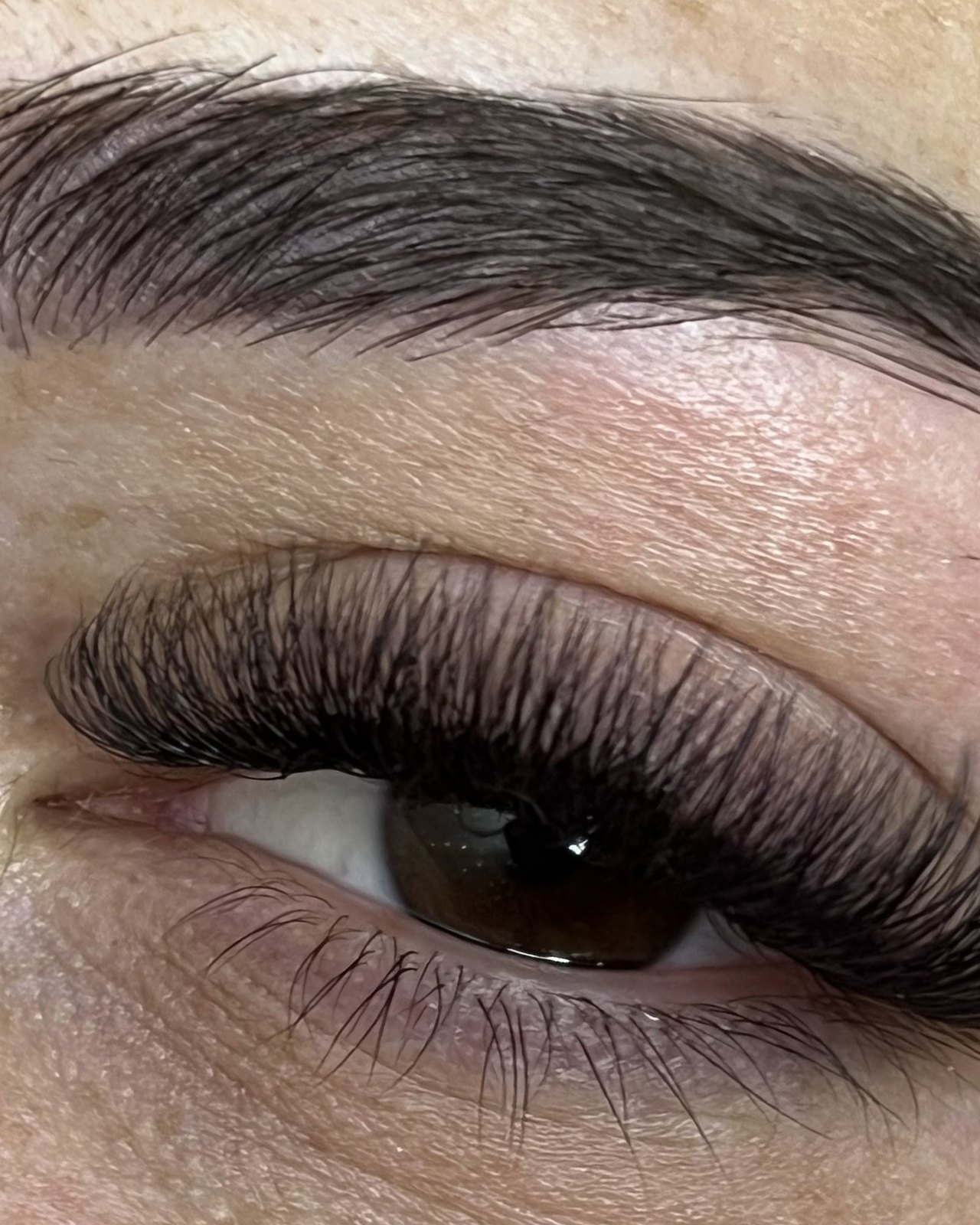 Volle set wimperextensions met strak gevormde wenkbrauw, van dichtbij