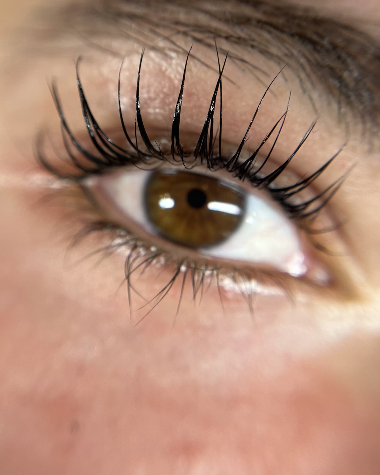 Gelifte eigen wimpers boven een bruin oog